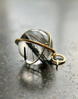 black tourmaline in quartz orb captured in 18k gold pendant