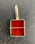 14k gold carnelian pendant on a gray surface