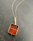 14k gold Necklace with a carnelian pendant on a gray surface