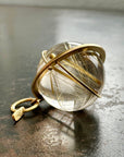 golden rutilated quartz orb pendant captured in 18k gold