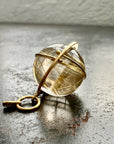 golden rutilated quartz orb pendant captured in 18k gold