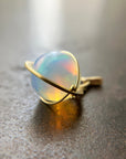 An ethiopian opal orb pendant in an 18k gold setting