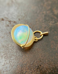 An ethiopian opal orb pendant in an 18k gold setting