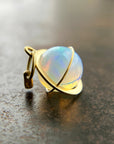 An ethiopian opal orb pendant in an 18k gold setting