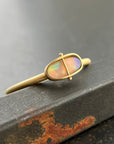 Gold ring with an opal gemstone on a dark surface