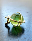 An 18k gold orb pendant with a green peridot sphere gemstone.