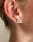 peruvian blue opal round studs in 18k gold on a model.
