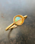 Gold ring with a opal stone on a textured surface