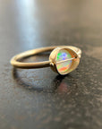 Gold ring with an opal gemstone on a dark surface