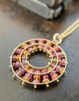 sapphire bead pendant with concentric circles of 14k gold