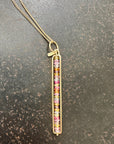 Necklace with a colorful sapphire beaded pendant on a dark surface