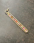 Necklace with a colorful sapphire beaded pendant on a dark surface