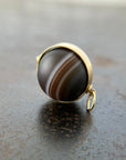 saturn agate orb with bands of color set in 18k gold