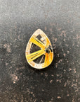A teardrop-shaped gemstone featuring a striking golden-yellow radial pattern with a small dark inclusions, centered on a dark surface.