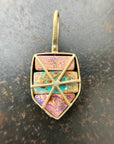 A shield-shaped pendant featuring an 18k gold frame and three rectangular inlay wood replacement opals in pink, turquoise, purple, and brown.