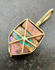 A shield-shaped pendant featuring an 18k gold frame and three rectangular inlay wood replacement opals in pink, turquoise, purple, and brown.