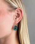 model wearing ammonite with embedded turquoise earrings in silver and gold on gold hooks