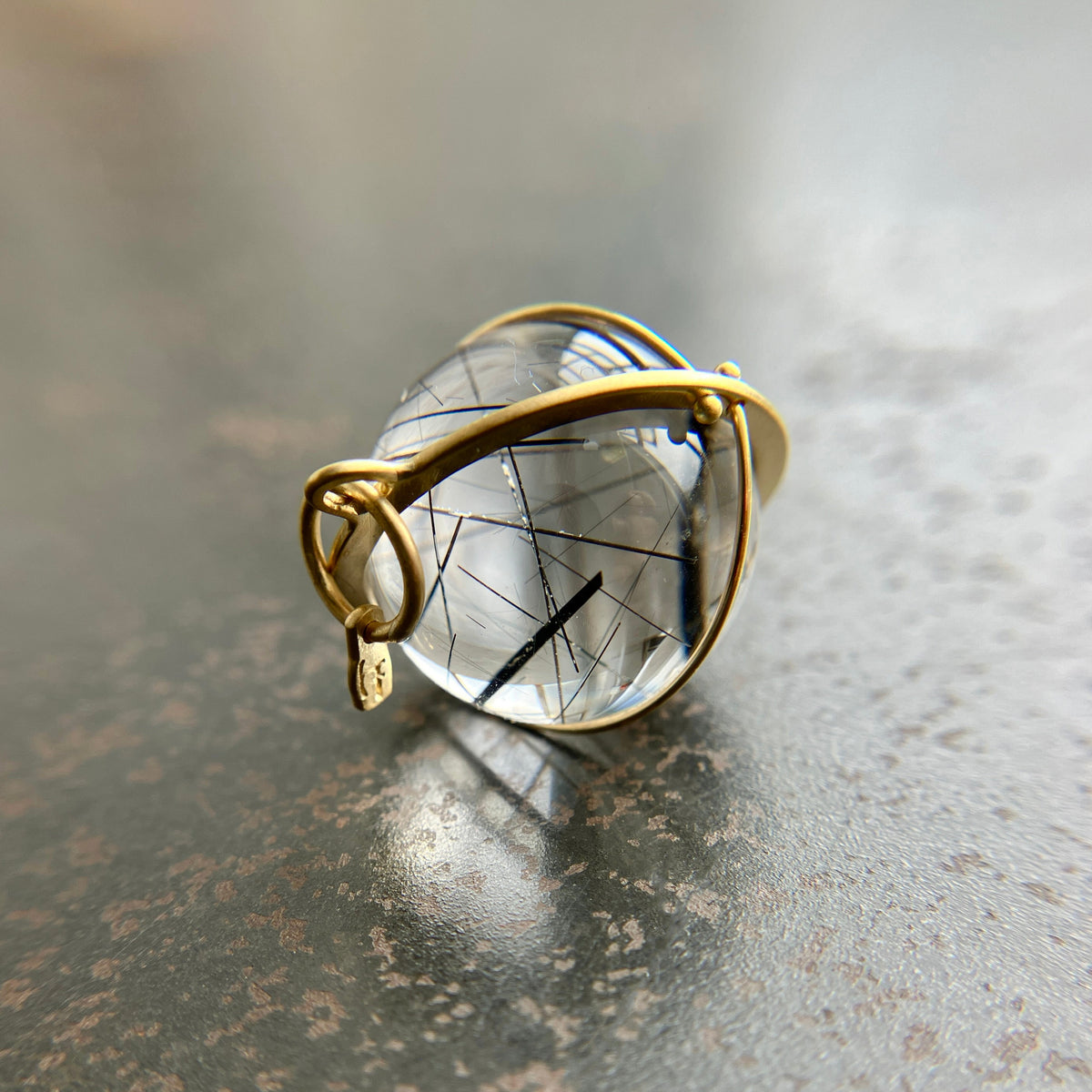 black tourmaline in quartz orb captured in 18k gold pendant