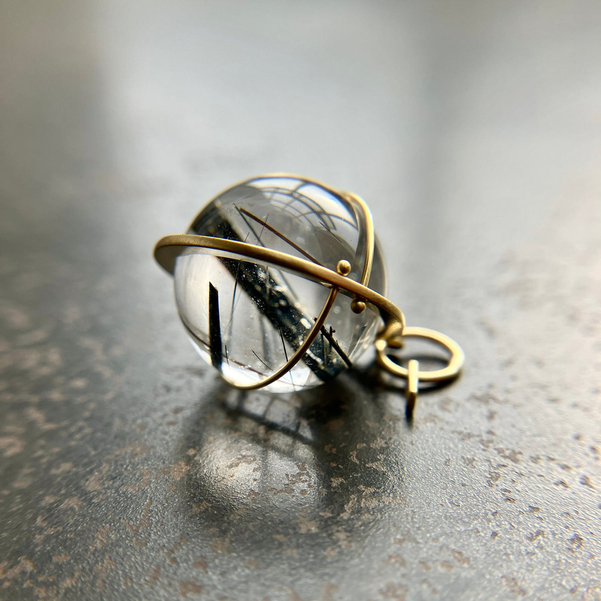 black tourmaline in quartz orb captured in 18k gold pendant