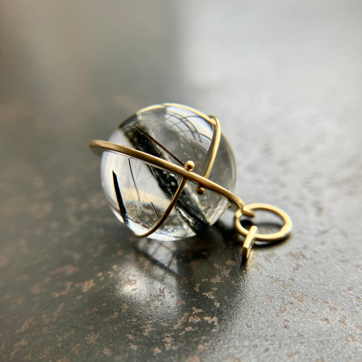 black tourmaline in quartz orb captured in 18k gold pendant