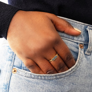 Hand with a blue diamond gold ring in a pocket of blue jeans