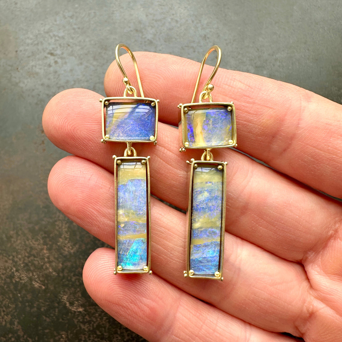 boulder opal earrings with purple and golden stripes Captured in 18k gold frames