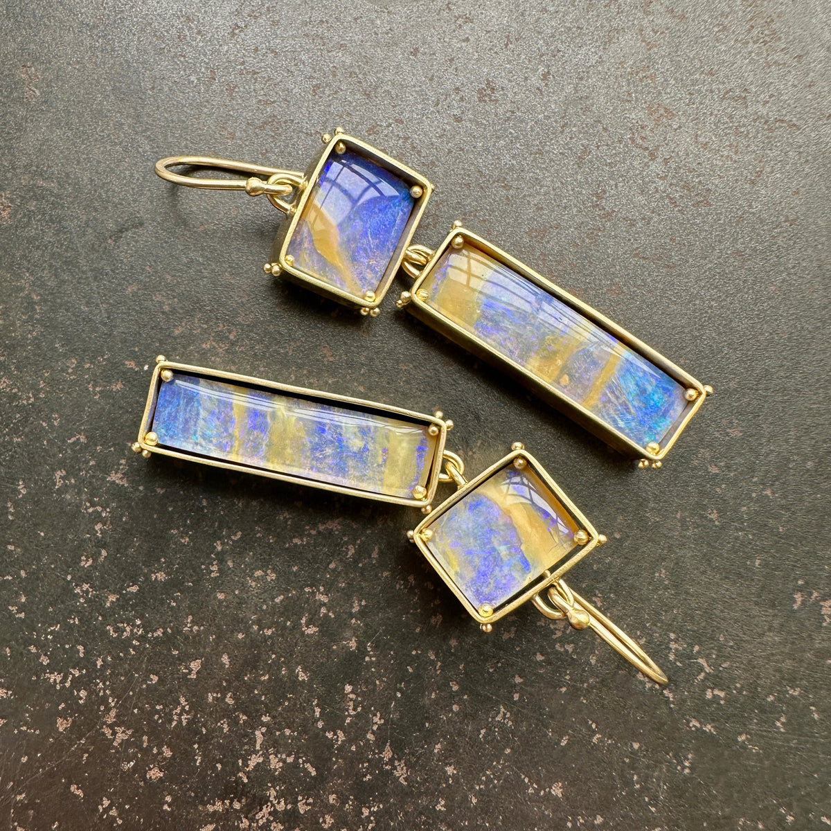 boulder opal earrings with purple and golden stripes Captured in 18k gold frames