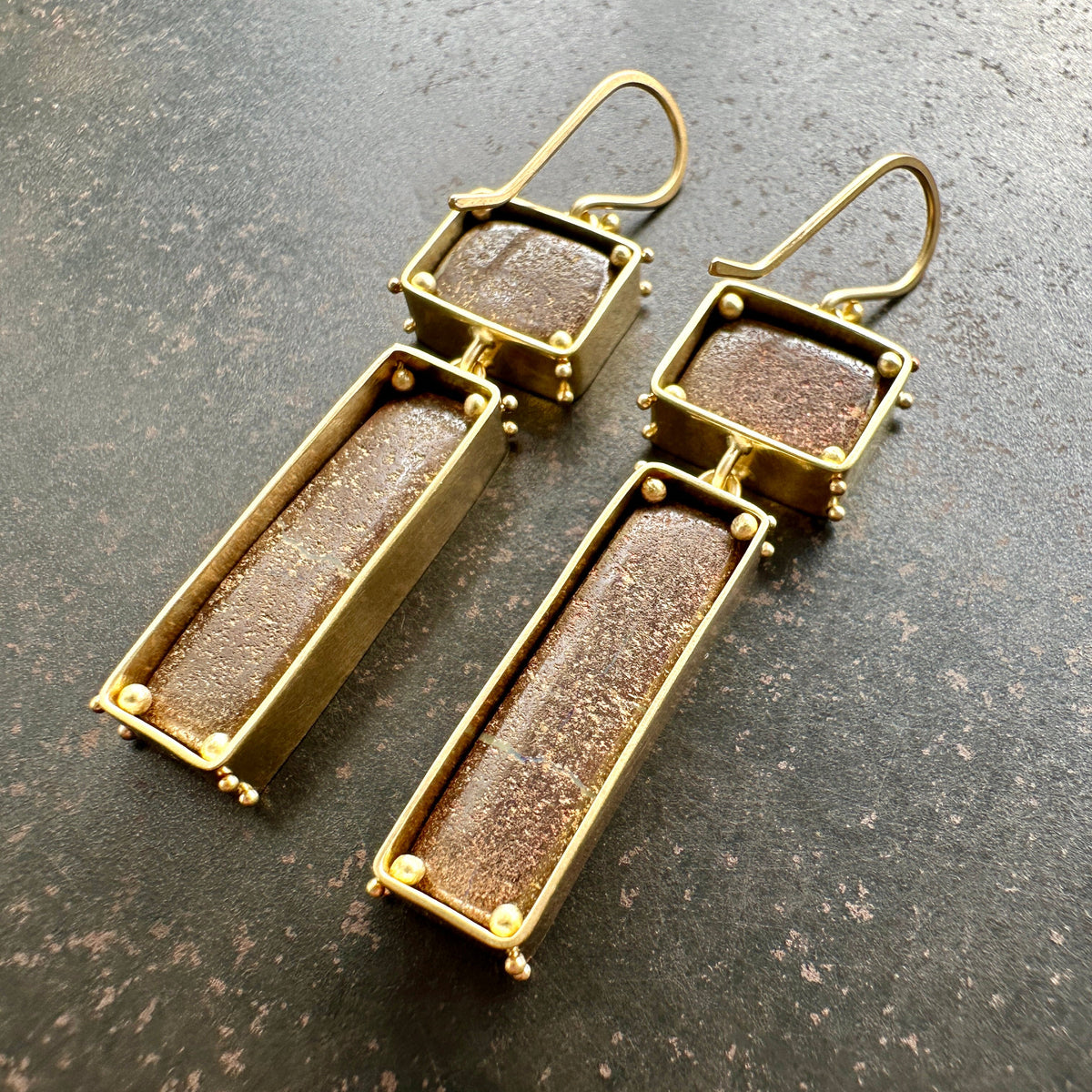 boulder opal earrings with purple and golden stripes Captured in 18k gold frames