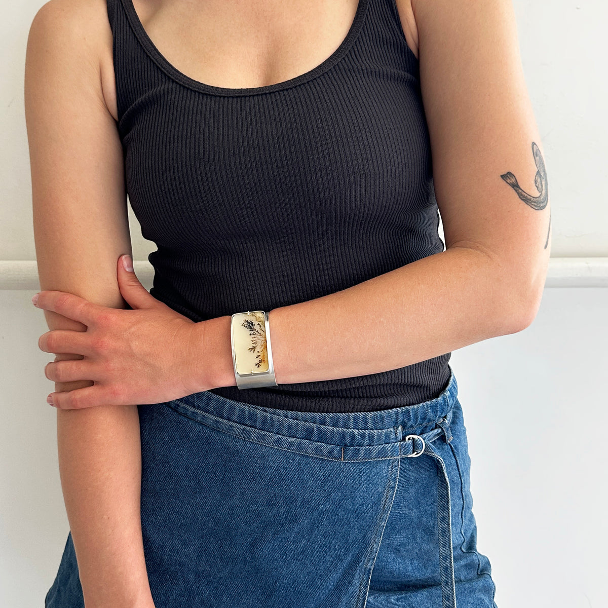 model wearing a silver cuff bracelet with dendritic agate stone