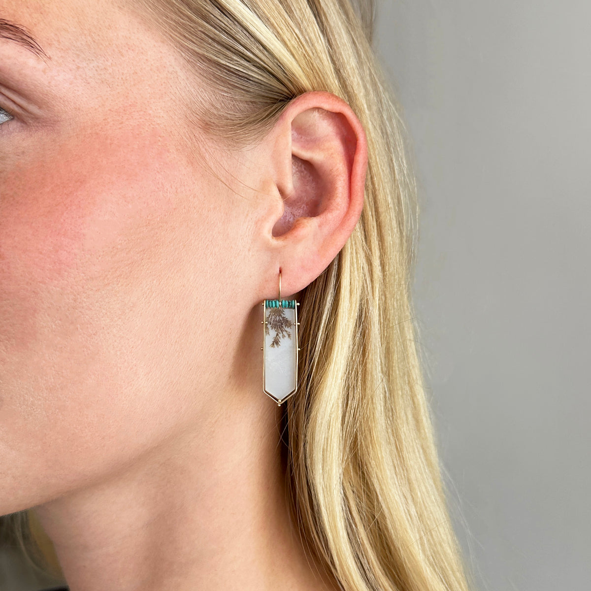 model wearing dendritic agate and persian turquoise drop earrings in 14k gold