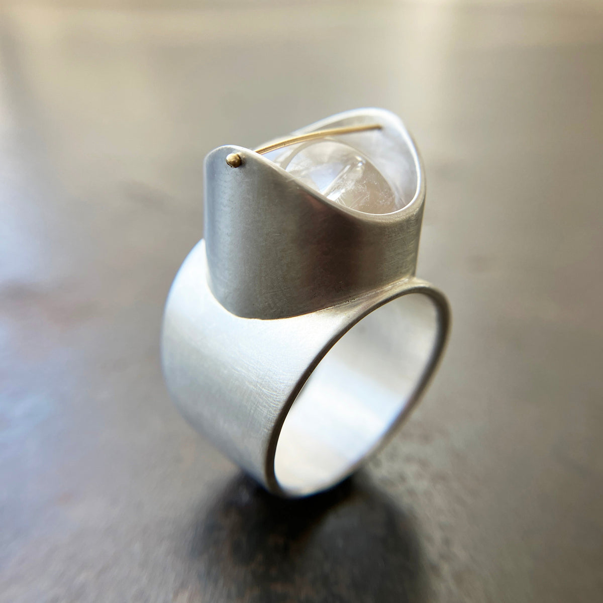 Silver ring with a enhydro quartz stone set with a gold crossbar
