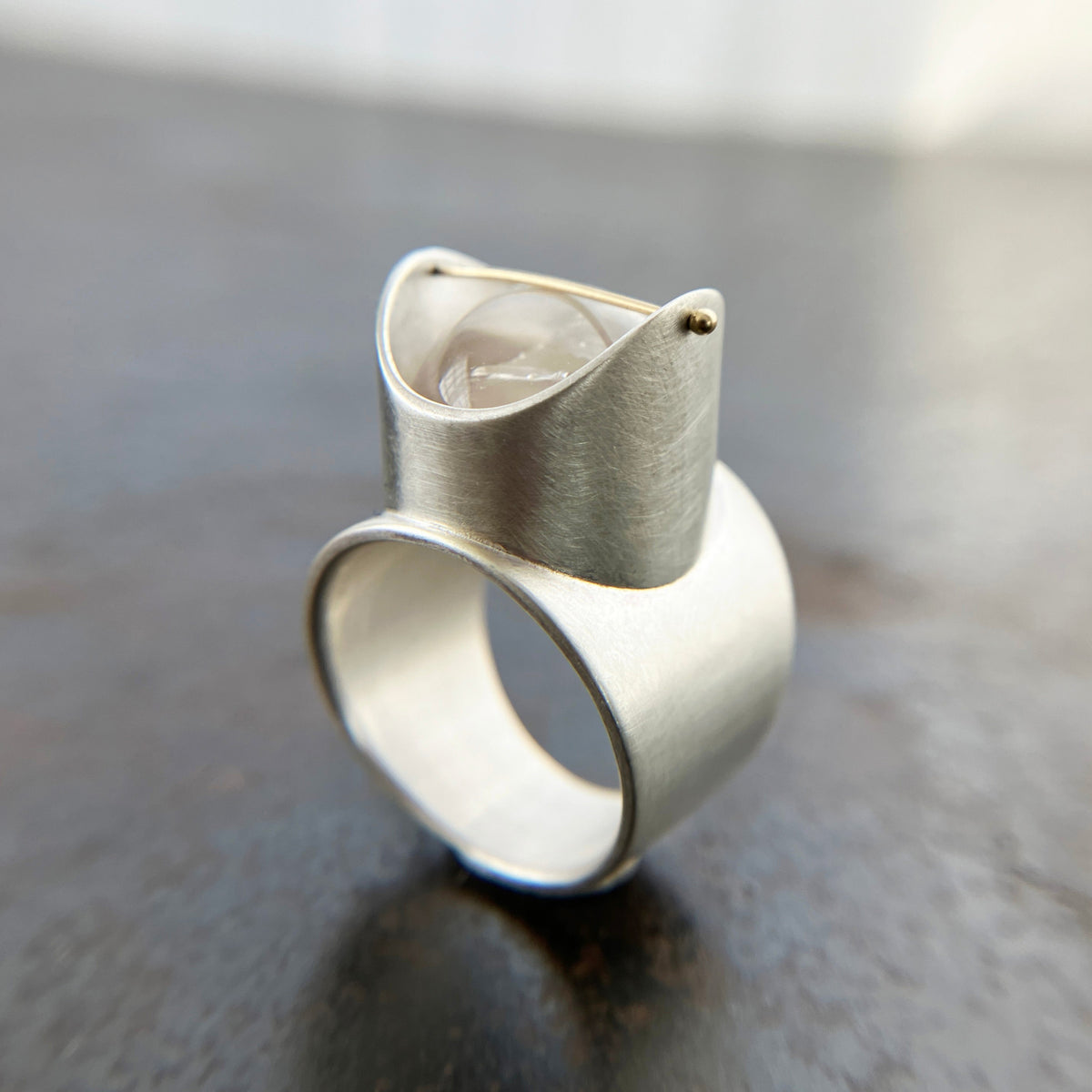 Silver ring with a enhydro quartz stone set with a gold crossbar