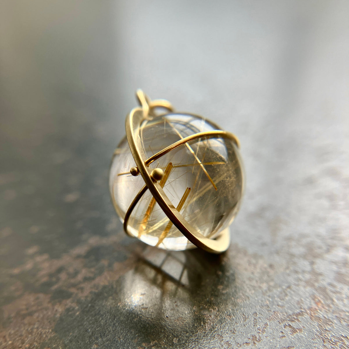 golden rutilated quartz orb pendant captured in 18k gold