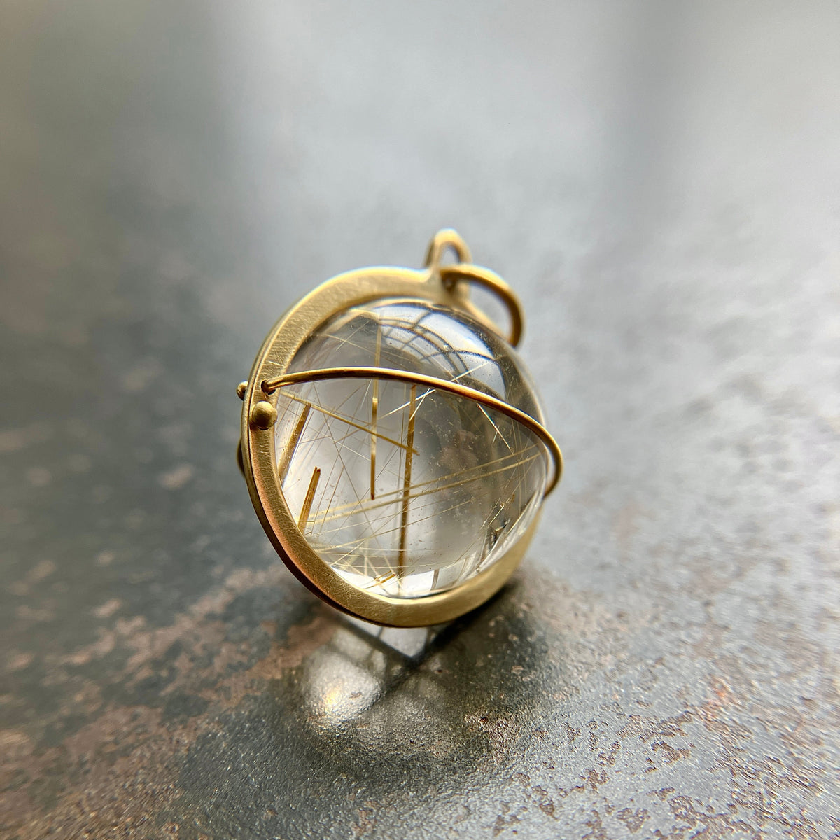 golden rutilated quartz orb pendant captured in 18k gold