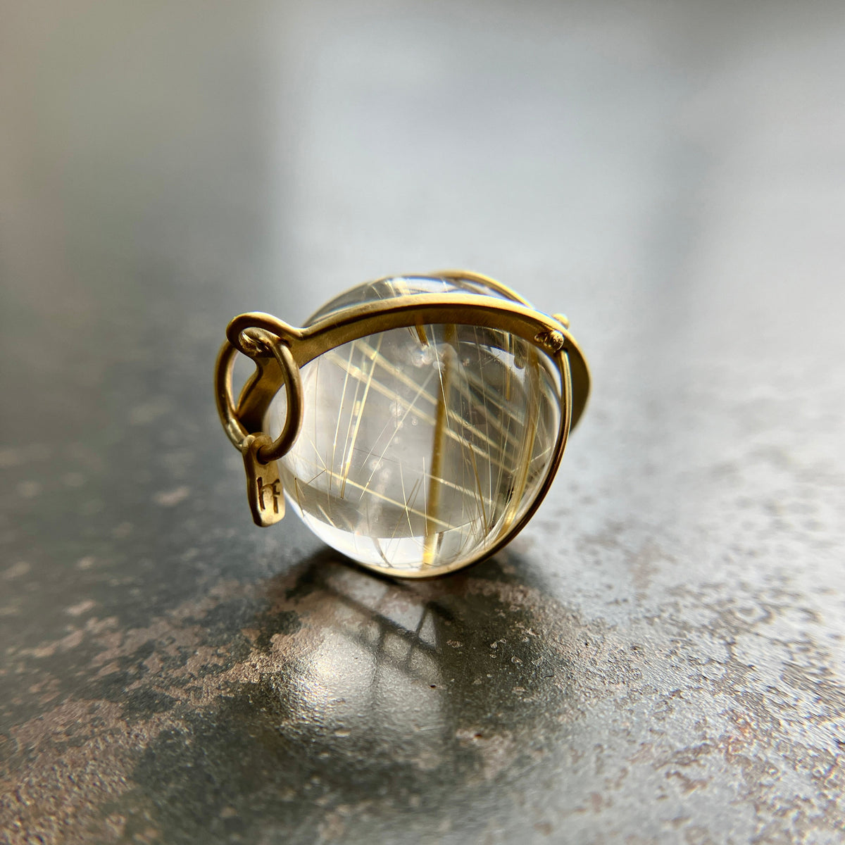 golden rutilated quartz orb pendant captured in 18k gold