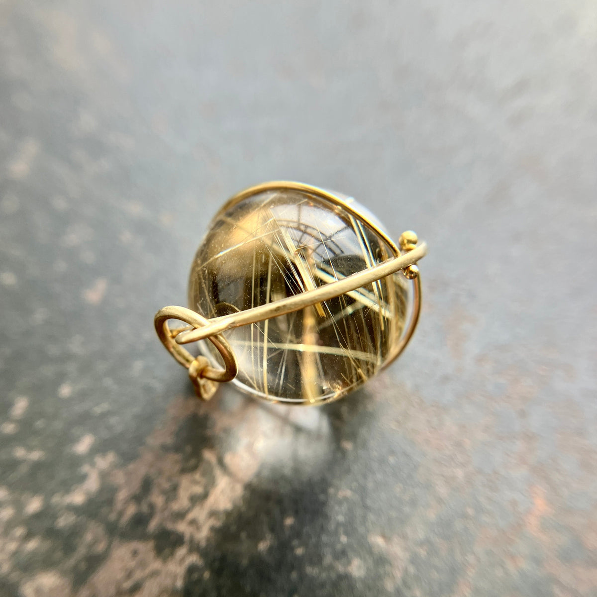 golden rutilated quartz orb pendant captured in 18k gold