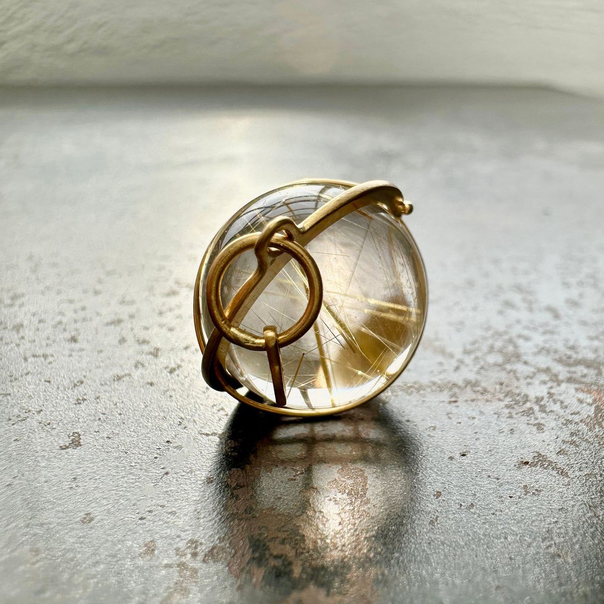 golden rutilated quartz orb pendant captured in 18k gold