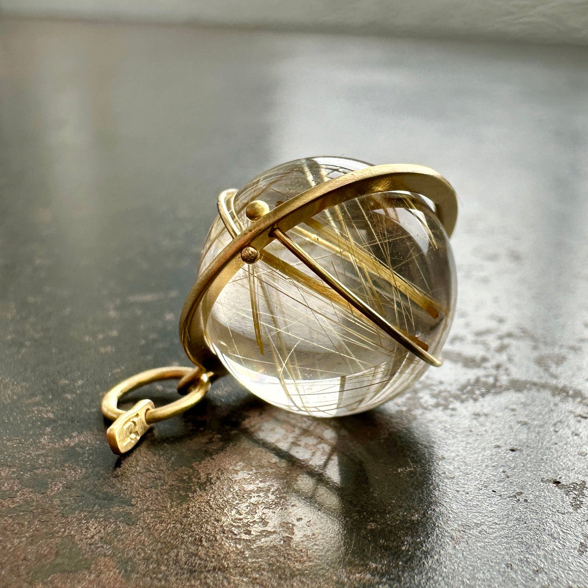 golden rutilated quartz orb pendant captured in 18k gold