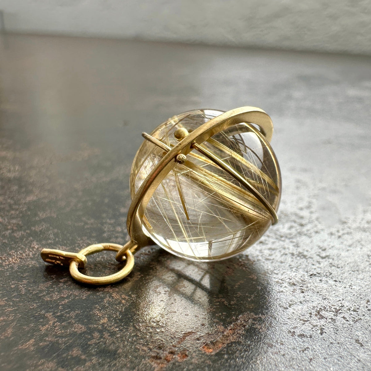 golden rutilated quartz orb pendant captured in 18k gold