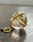 golden rutilated quartz orb pendant captured in 18k gold