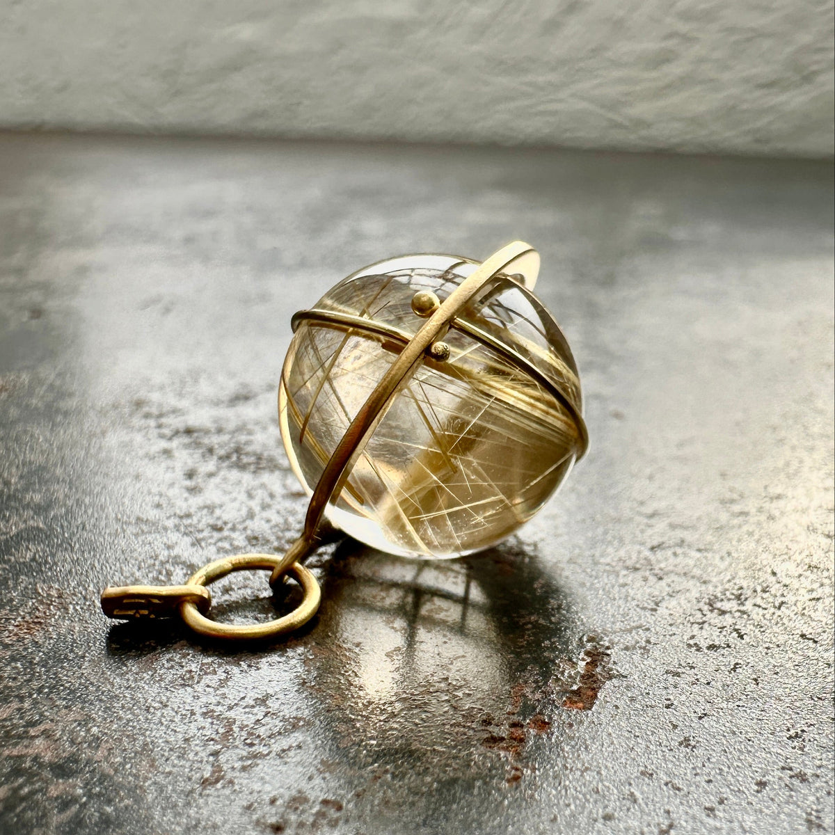 golden rutilated quartz orb pendant captured in 18k gold