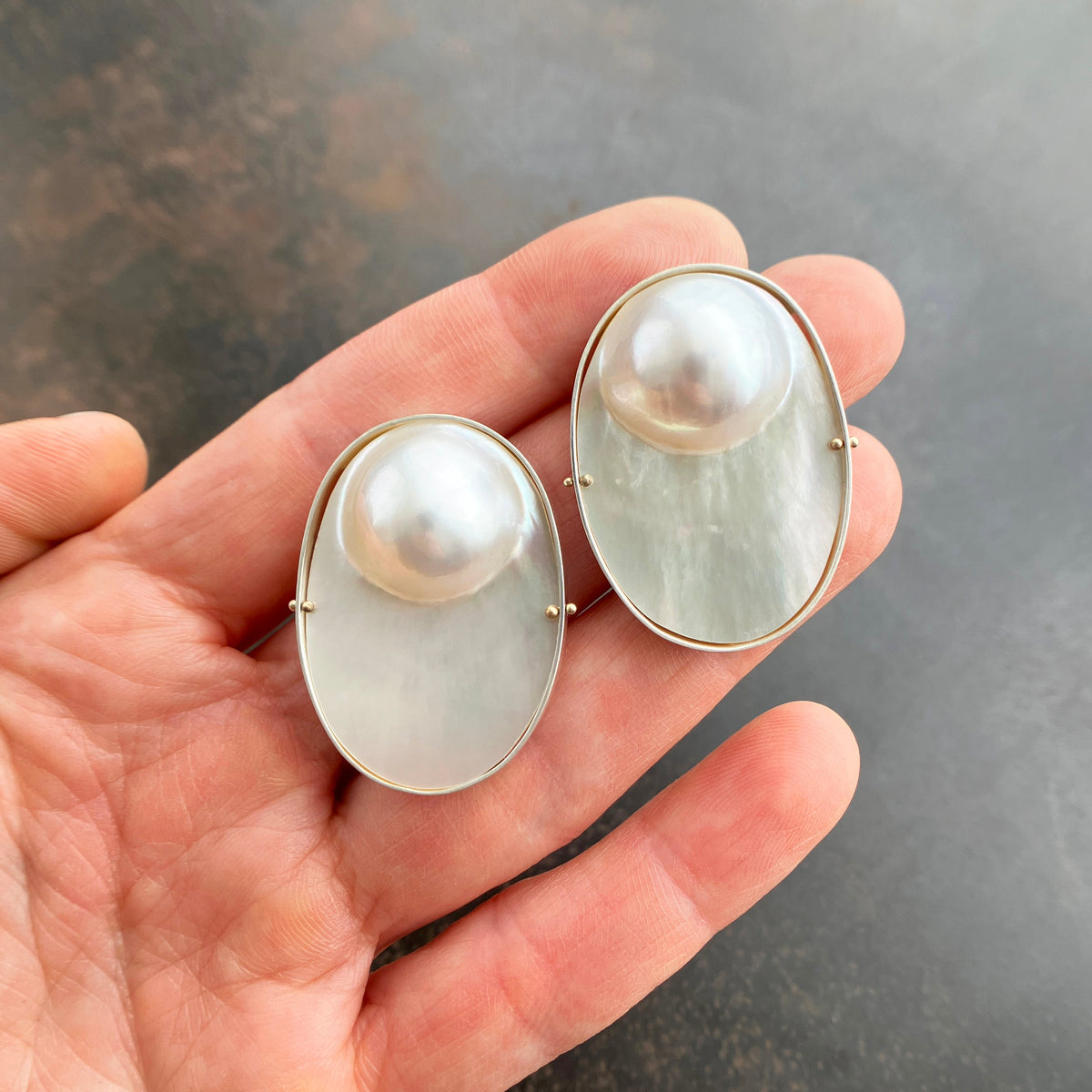 oval mabe pearl earrings set in sterling silver with 14k gold ball rivets