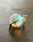 An ethiopian opal orb pendant in an 18k gold setting