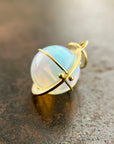 An ethiopian opal orb pendant in an 18k gold setting