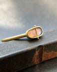 Gold ring with an opal gemstone on a dark surface