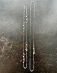 silver paperclip chains with clasp on a dark textured background