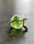 An 18k gold orb pendant with a green peridot sphere gemstone.