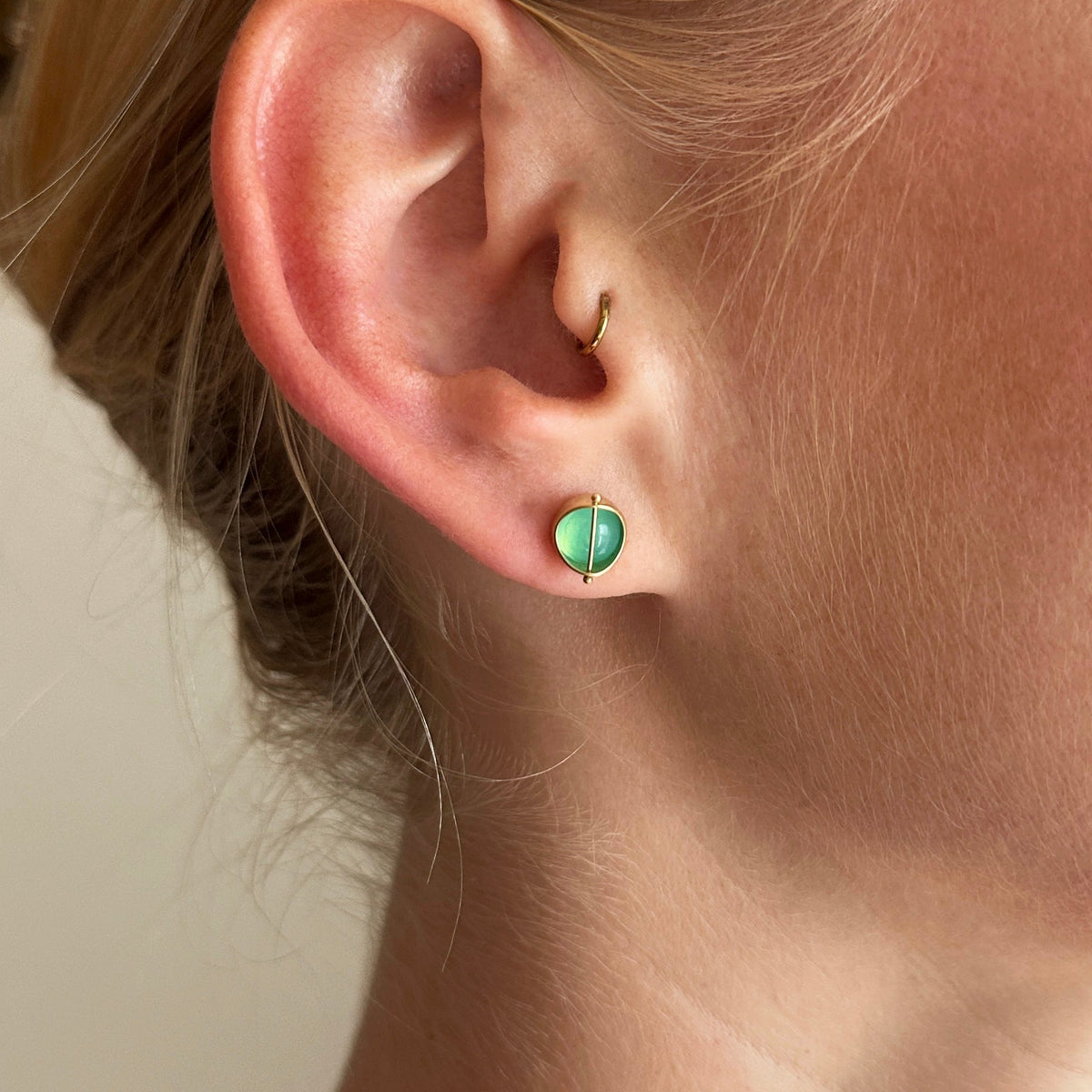 peruvian blue opal round studs in 18k gold on a model.