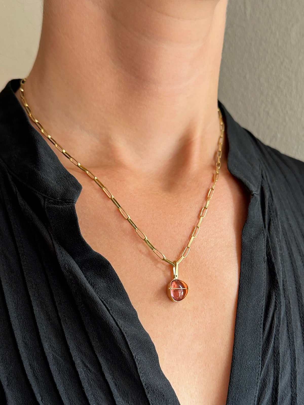 pink tourmaline oval pendant in 18k gold on a model