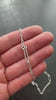 Silver  figaro chain necklace on a textured dark surface